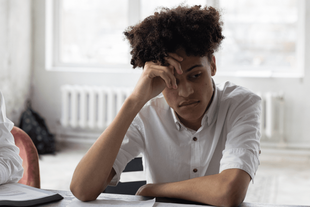 Man in a white button-up shirt thinking and reflecting on how to cope with shame and regret.