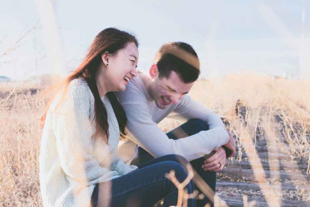 Asian couple laughing and sitting down