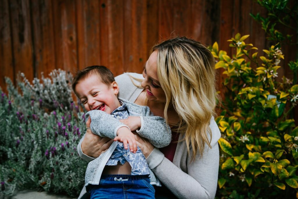Attractive blonde mom holding son and laughing