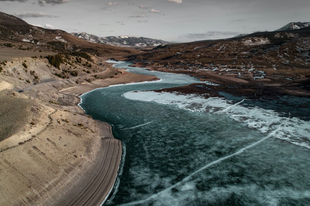 A blue river winding through a mountainous valley, symbolizing overcoming porn withdrawal.