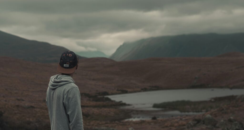 Man reflecting on porn addiction recovery while overlooking a river valley.