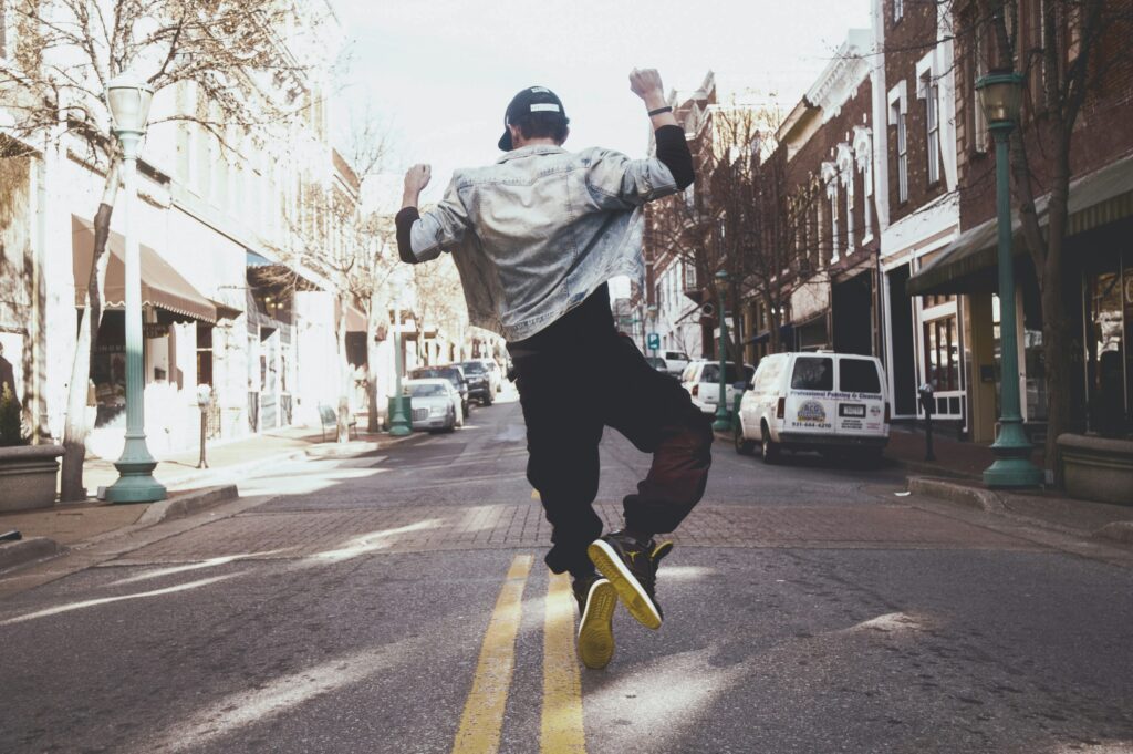 Person joyfully jumping in the street, celebrating freedom from anxiety and the achievement of treatment goals.