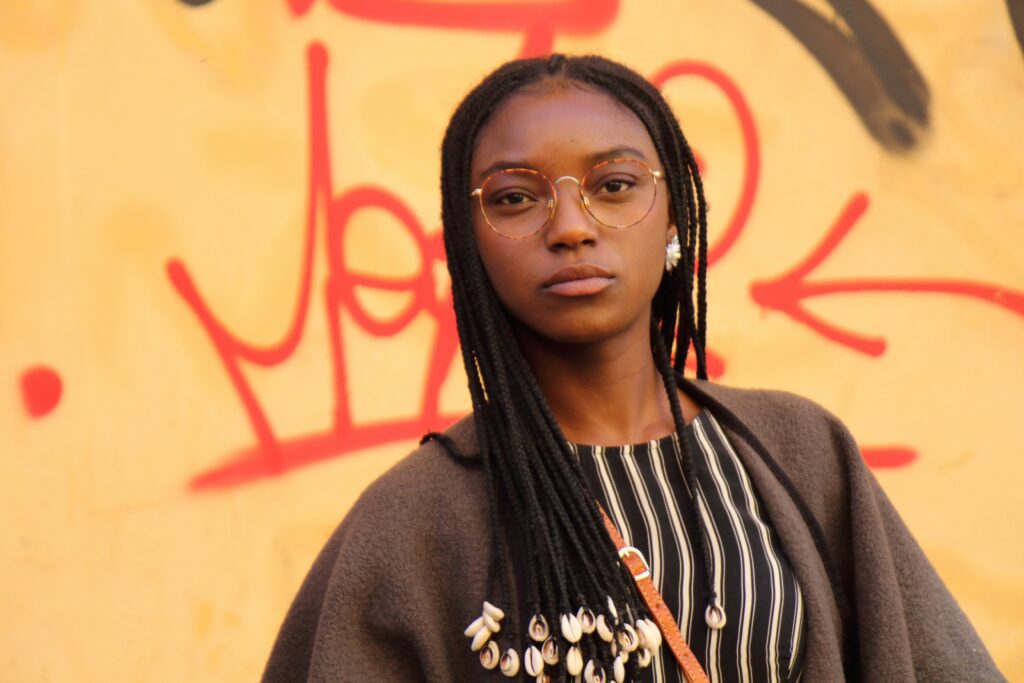 A confident woman stands strong against a bold backdrop, embodying self-assurance, identity, and purpose.