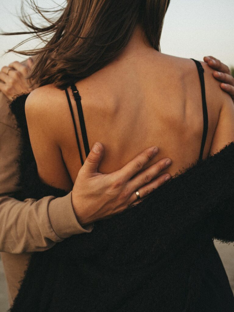 A close-up of a partner gently touching their lover's back, engaging in Sensate Focus to enhance physical connection.
