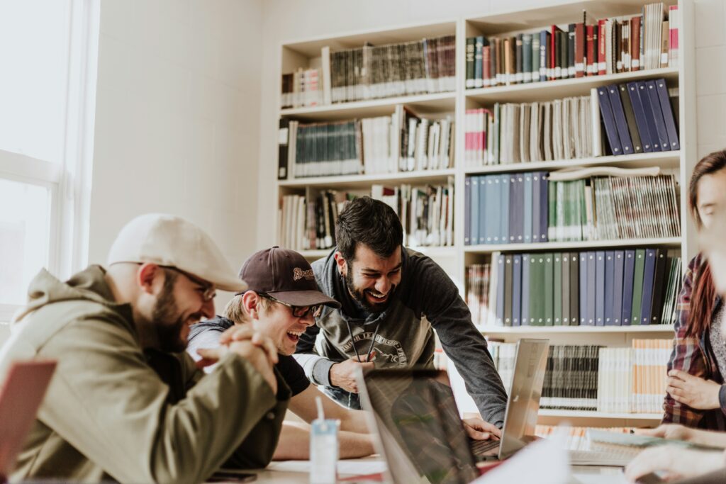 People working together in a library, showing how mentorship and learning environments can foster chosen family relationships