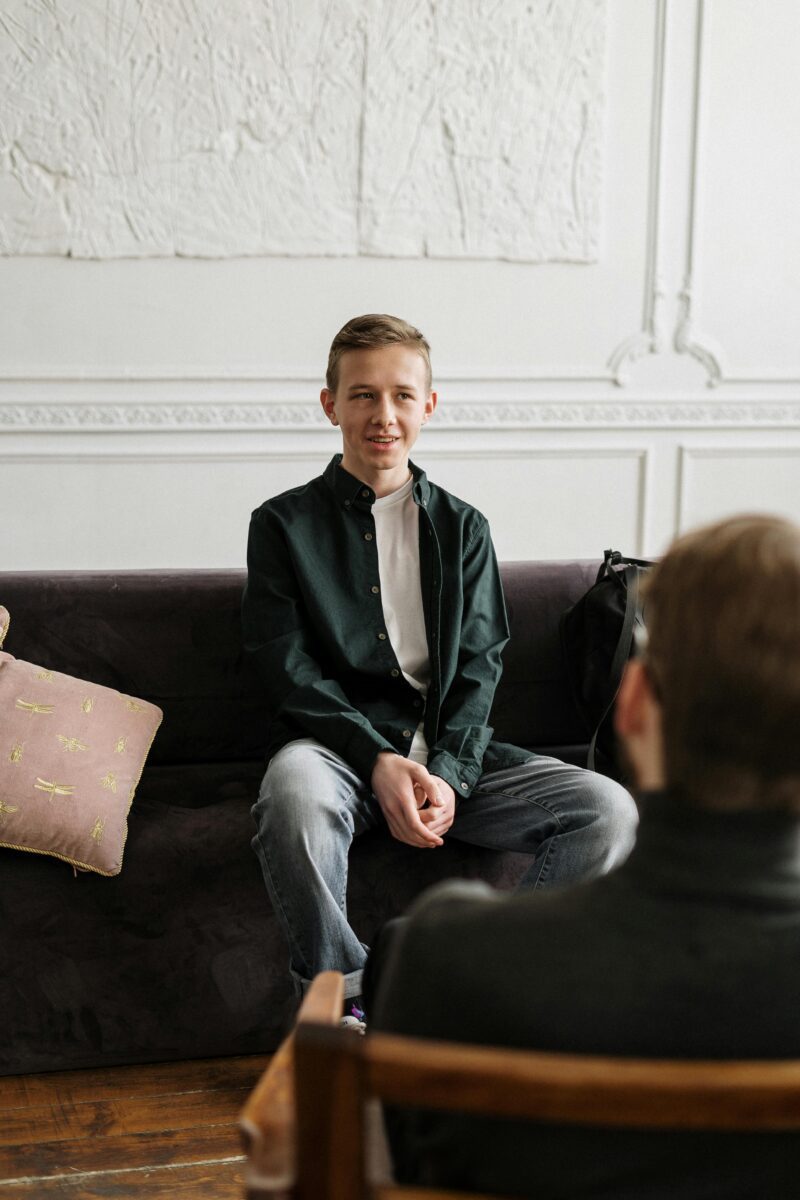 A young man in a counseling session, engaging in open conversation in a supportive and welcoming environment.