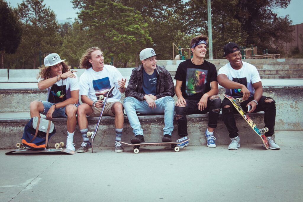 Young friends with skateboards sitting together, demonstrating how youth form meaningful connections