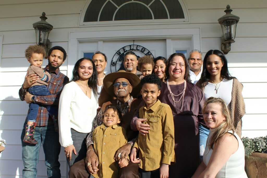 Multi-generational blended hispanic family sitting on porch