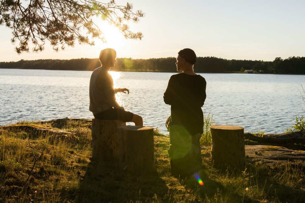 Family members having a conversation at sunset by a lake