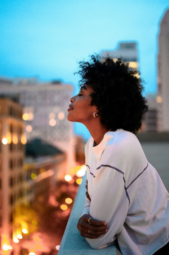 Black woman on top of Chicago building smiling because she is healing from complex trauma.