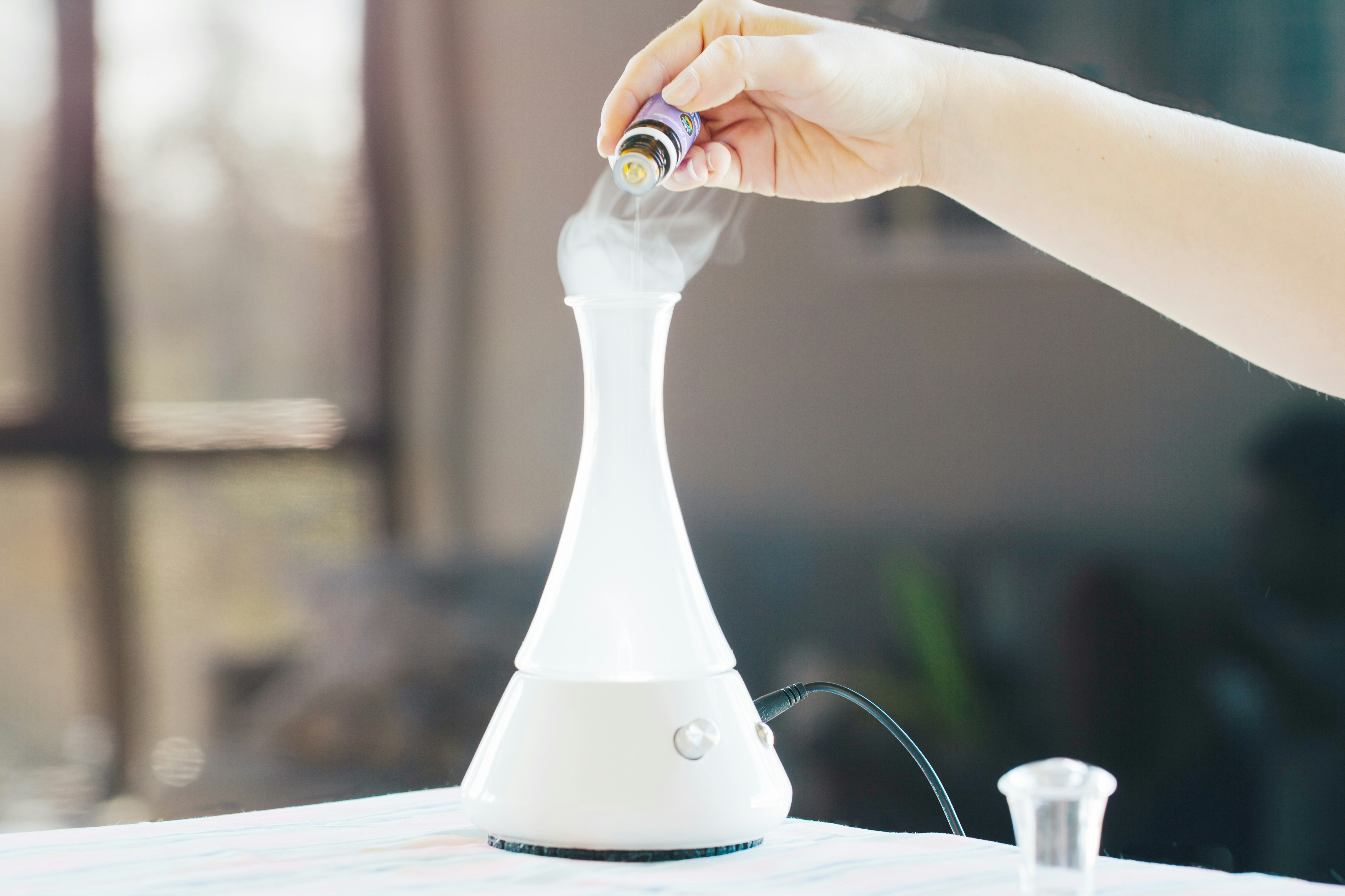 Adding essential oil to diffuser for OCD support, calming aromatherapy mist for relaxation and focus