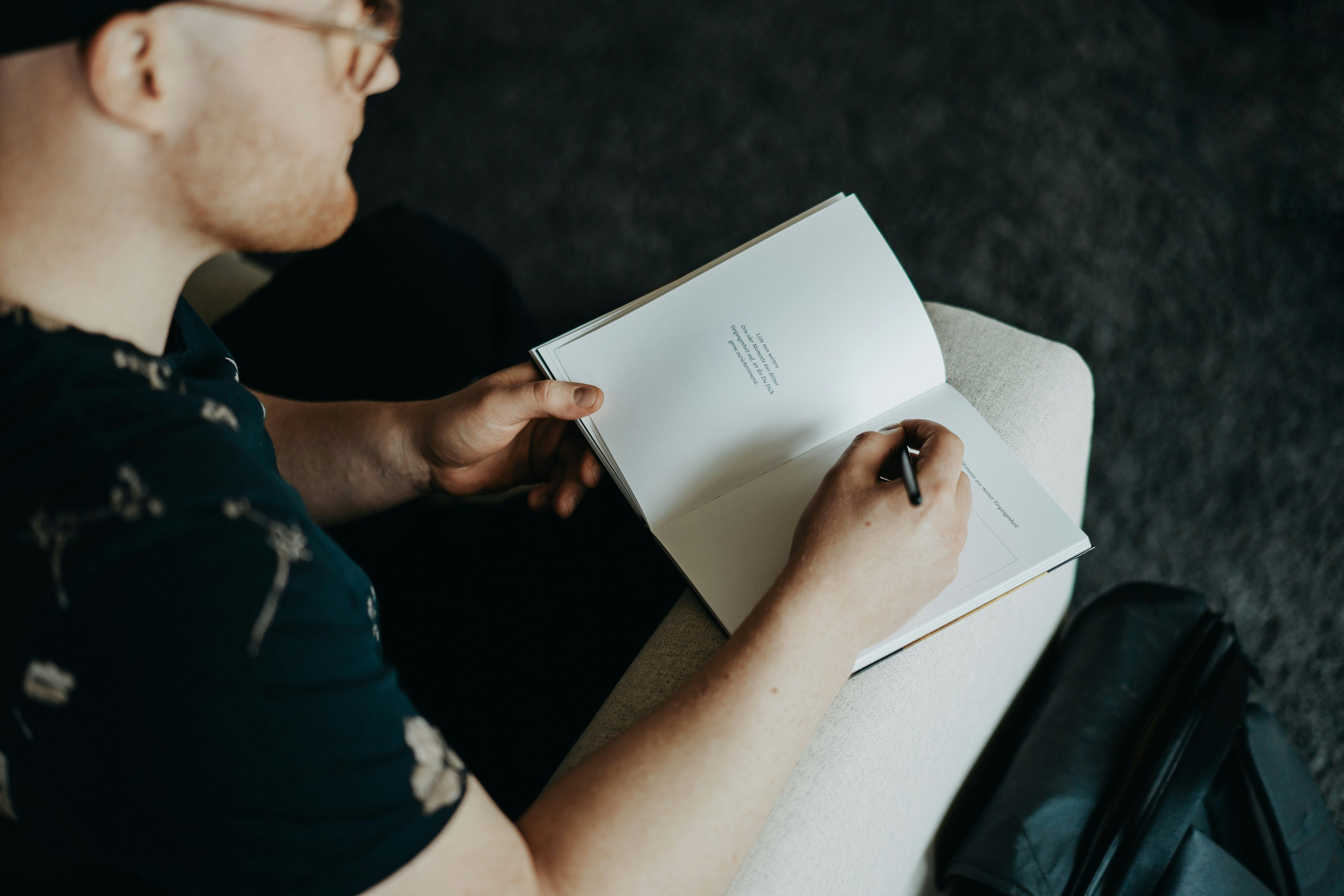 Man sitting and writing reflections in a guided journal