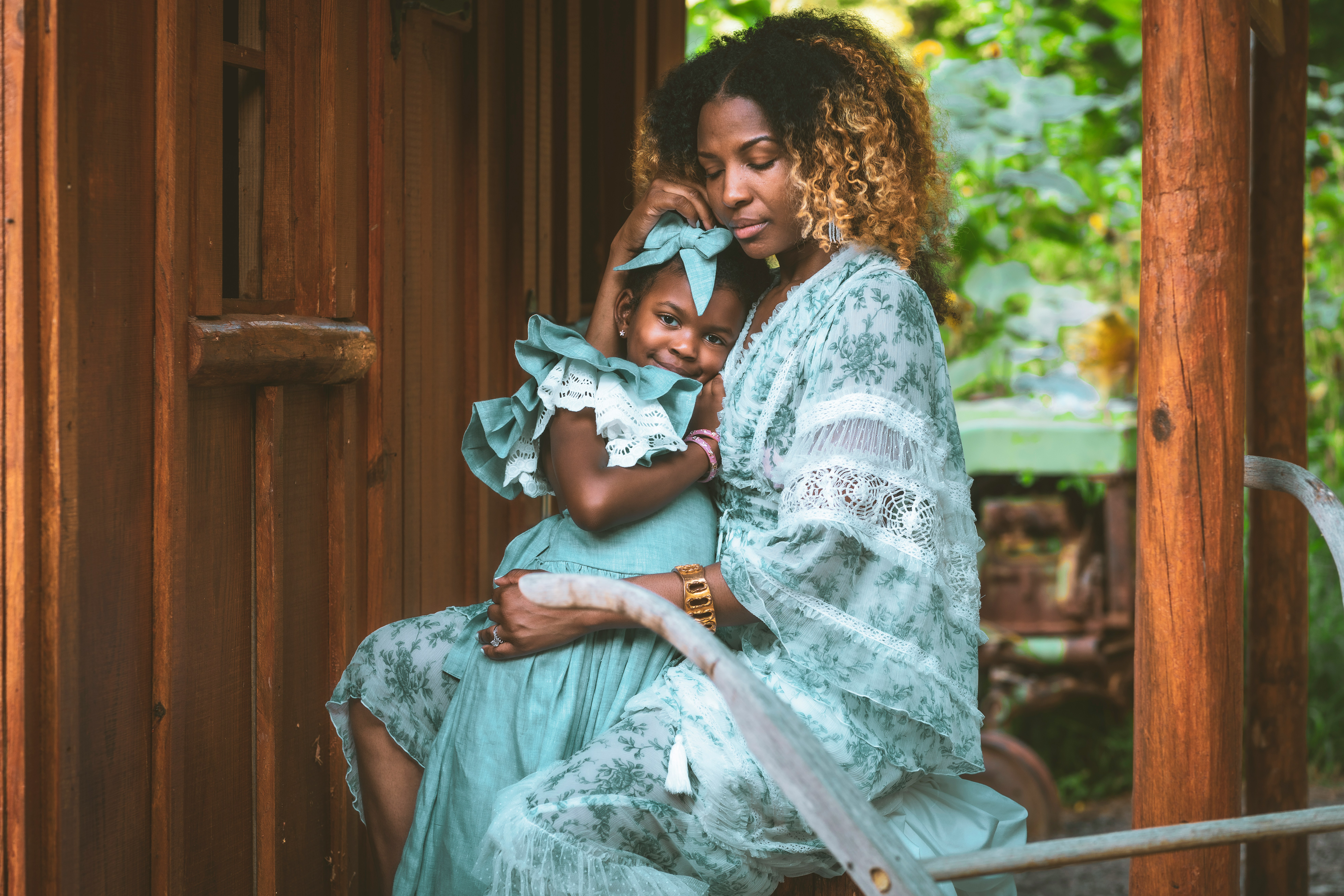 Mother gently holding her daughter on a porch — capturing love, comfort, and emotional connection after loss