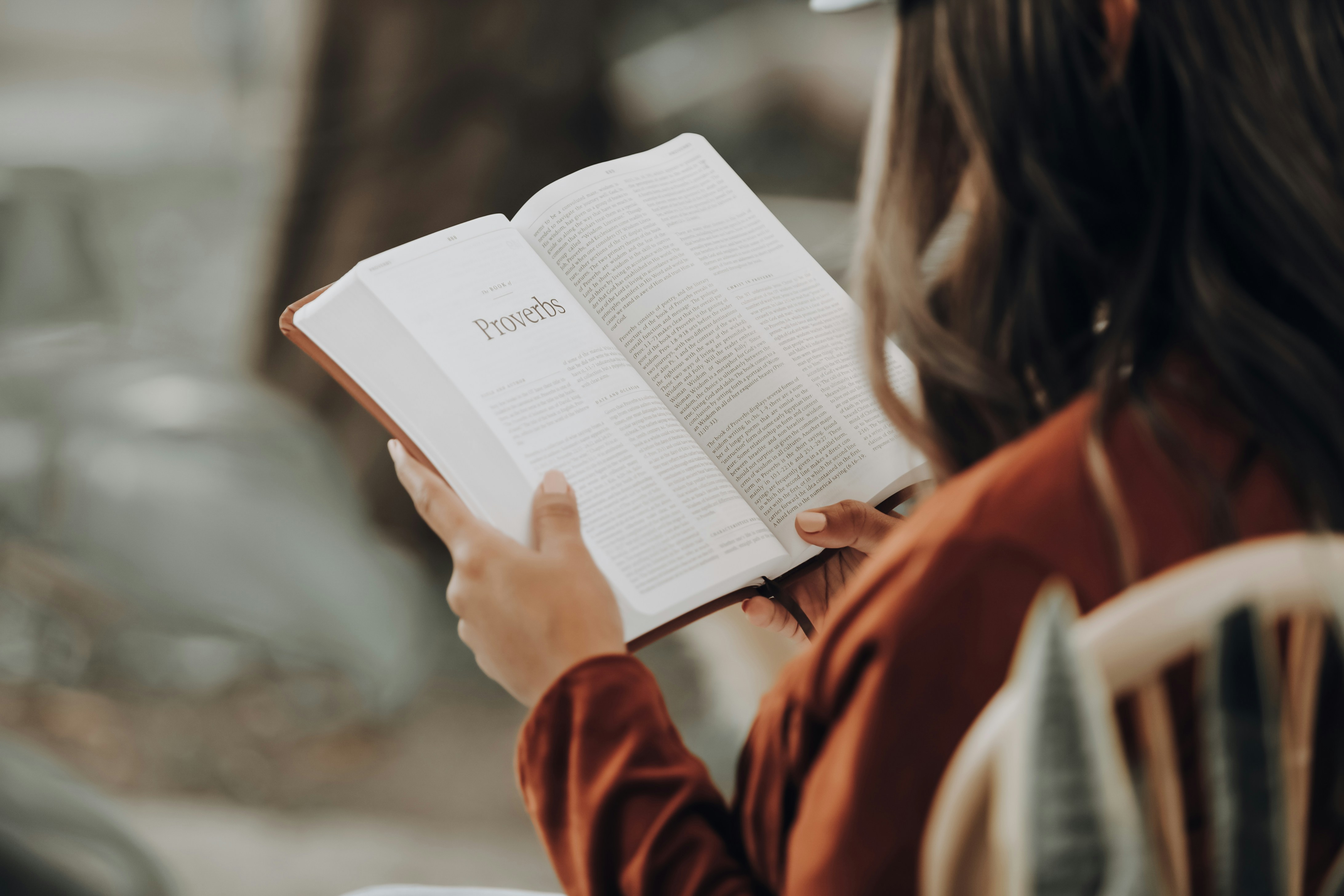 Person reading the book of Proverbs in the Bible, symbolizing faith and reflection for anxiety relief