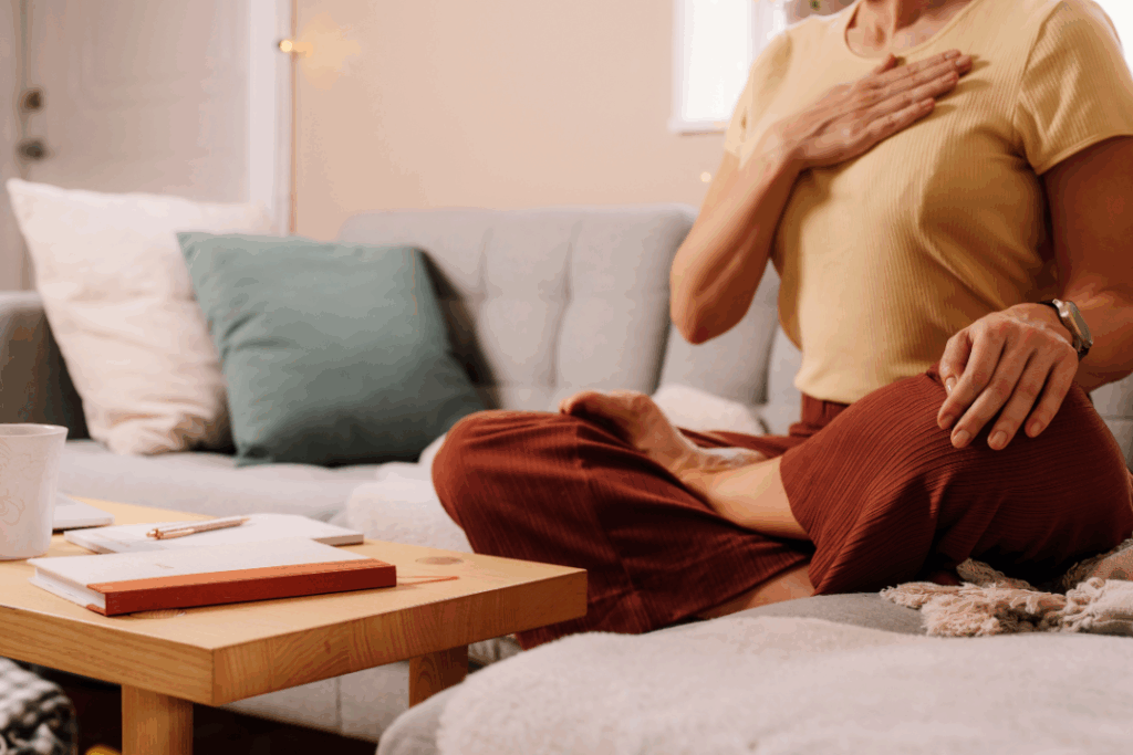 A girl wearing yellow shirt, sitting in a couch, practicing self regulation and healing exercise. 