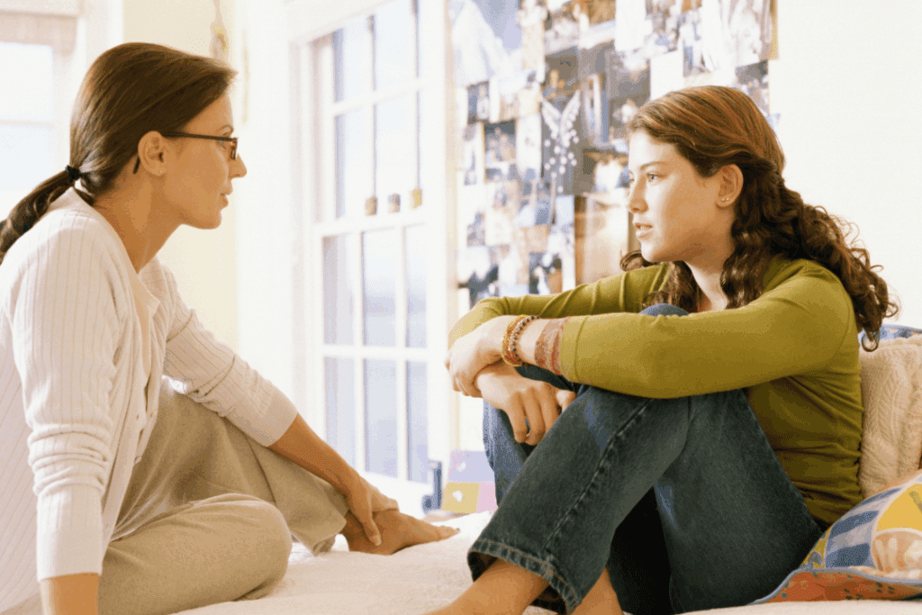 A mother having conversation with her daughter, while both sitting in bed, trying to be transparent with each other. 